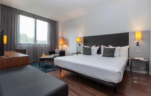 um quarto de hotel com uma cama grande e uma secretária em Hotel Palau de Bellavista Girona by URH em Girona