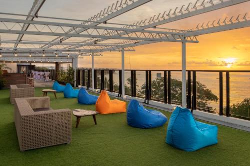 a room with blue and orange chairs and a view of the ocean at Truntum Kuta Bali in Kuta