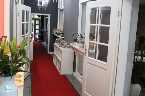 a kitchen with white doors and a red carpet at Altstadtcafé und Pension in Havelberg