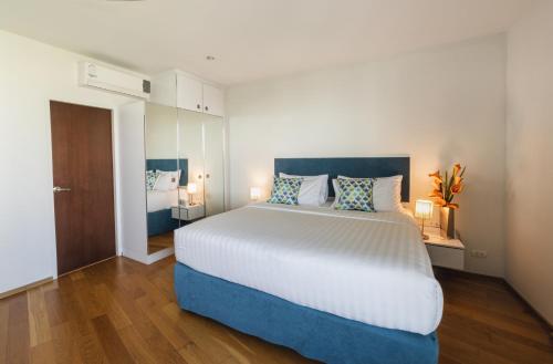 um quarto com uma cama grande e 2 candeeiros em First Choice Grand Suites Sha Plus Extra em Hua Hin