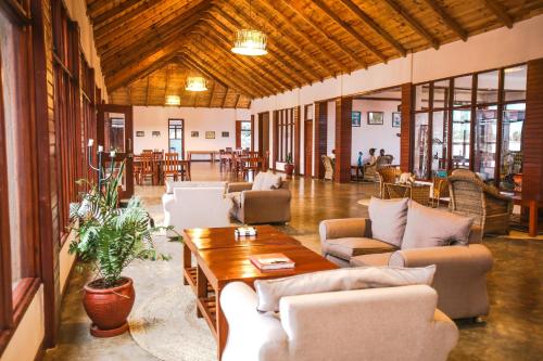 a large living room with couches and a table at Ngorongoro Marera Mountain View Lodge in Karatu