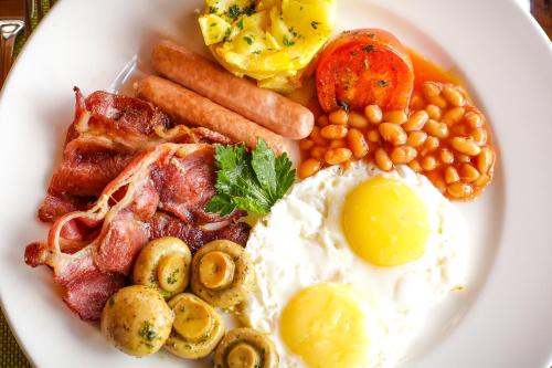 a plate of breakfast food with eggs bacon beans and carrots at Ngorongoro Marera Mountain View Lodge in Karatu