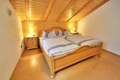 una camera con un grande letto in legno di Ferienwohnung Brigitte Frank a Bärnau