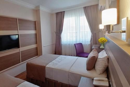 A bed or beds in a room at Sembol Hotel