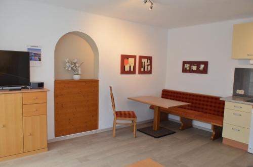 a living room with a table and a bench at Haus Regenbogen in Pertisau