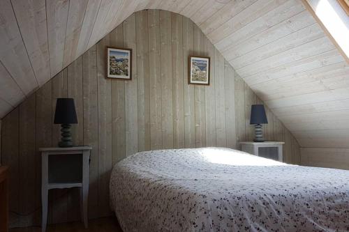 ein Schlafzimmer mit einem Bett und zwei Tischen mit Lampen in der Unterkunft Cleuziou Vraz in Lopérec