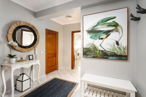 um corredor com uma grande pintura de um pássaro na parede em Bianca full apartment em Portimão