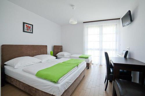 a bedroom with two beds and a desk and a desk at Willa Północna II in Karwia