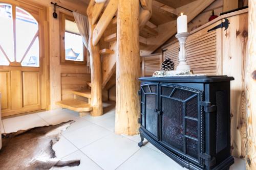 a room with a fireplace in a log cabin at TatryTop Osada Gazdówka z sauną in Kościelisko
