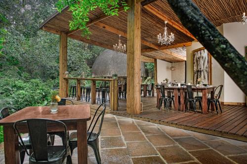 una gran terraza de madera con mesas y sillas en Serenity Mountain and Forest Lodge, en Malelane