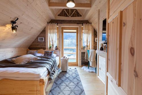 a bedroom in a log cabin with a bed at TatryTop Osada Gazdówka z sauną in Kościelisko