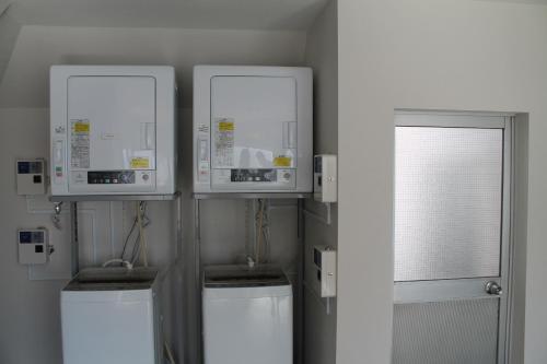 a room with two machines and two windows at Okubo Hotel Hawaii in Tokyo
