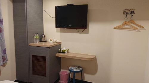 Zimmer mit einem TV in der Ecke eines Zimmers in der Unterkunft Wan Tai Hotel in Chiayi