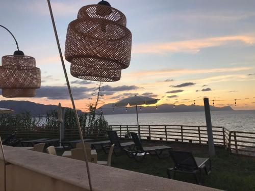 a group of chairs and umbrellas in front of the ocean at Marina Holiday & Spa in Balestrate