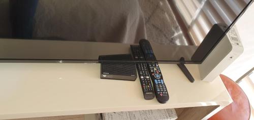 dos controles remotos sentados en la parte superior de un televisor en MATI´S APARTAMENT, en Antofagasta