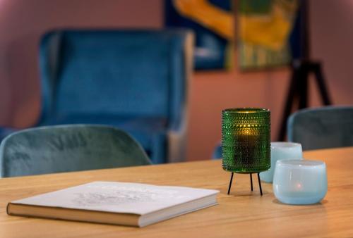 a book and a candle on a table with chairs at Four Stars by City Hotel in Meckenheim