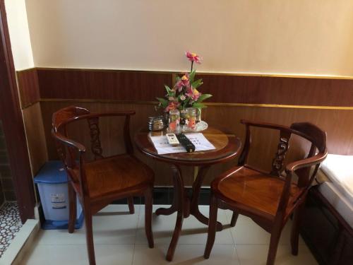 芹苴的住宿－Hong Dao 2 Hotel，小桌子,两把椅子和花瓶