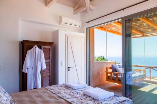 a bedroom with a bed and a view of the ocean at Villa Mirtes with breathtaking sea view,close to Porto Katsiki and Egremni in Póndi