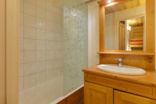 a bathroom with a sink and a mirror and a tub at Vacancéole - Résidence Champamé in Les Deux Alpes