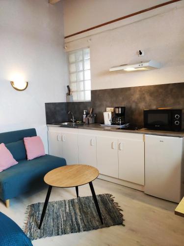 - un salon avec un canapé bleu et une table dans l'établissement Studio dans Villa historique "Victoria", à Argelès-Gazost