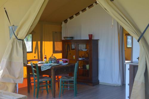a dining room with a table and chairs at Glamping Tenuta San Pierino Agriturismo in Rosignano Marittimo