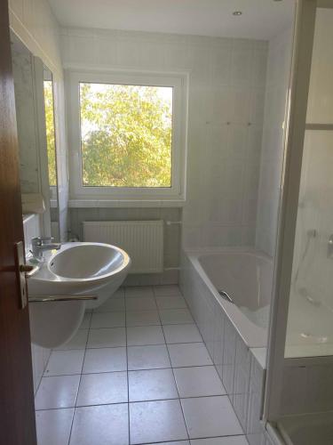 a bathroom with a sink and a tub and a sink and a bath tub at Grosszuegige Ferienwohnung in ruhiger Lage in Fulda