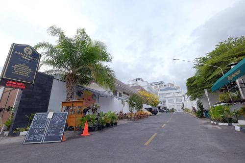 an empty street with a restaurant and a palm tree at Royal Darmo Malioboro in Yogyakarta