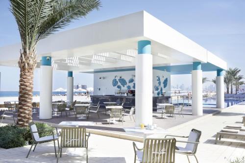 a beach area with chairs, tables and umbrellas at Riu Dubai - All Inclusive in Dubai