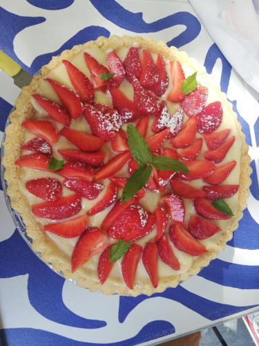 a pie with strawberries on top on a blue and white table at B&B Relais sul Siroto in Castelnuovo Cilento