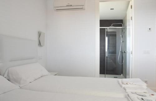 a white bedroom with a bed and a shower at Bodega Don Balbino in La puebla de Labarca 
