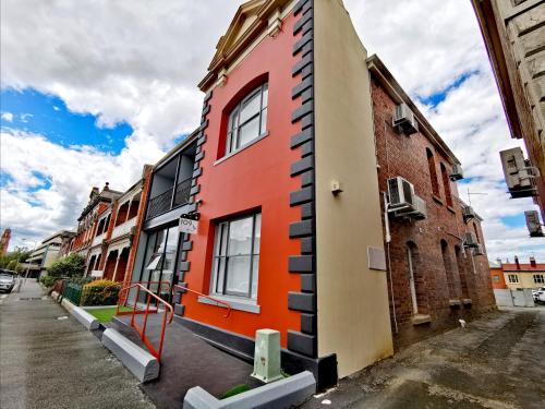 een oranje en zwart gebouw aan de straatkant bij Refresh109 on Cameron in Launceston