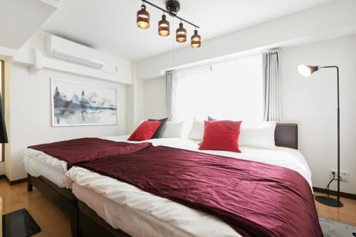 東京にあるHOTEL AIS HATAGAYAのベッドルーム1室(大型ベッド1台、赤い枕付)
