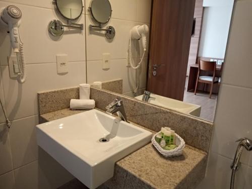 a bathroom with a sink and a mirror at Flat em Pedra Azul in Pedra Azul