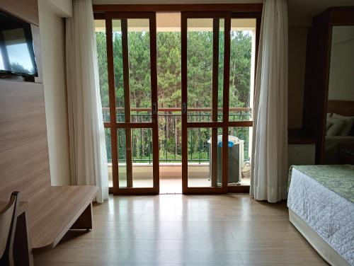 a bedroom with a door open to a balcony at Flat em Pedra Azul in Pedra Azul