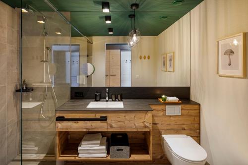 ein Bad mit einem Waschbecken, einem WC und einer Dusche in der Unterkunft Hotel Sport Klosters in Klosters