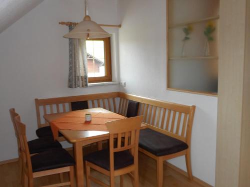 uma mesa de madeira e cadeiras num quarto com uma janela em Baby- und Kinderbauernhof Riegler em Rossleithen