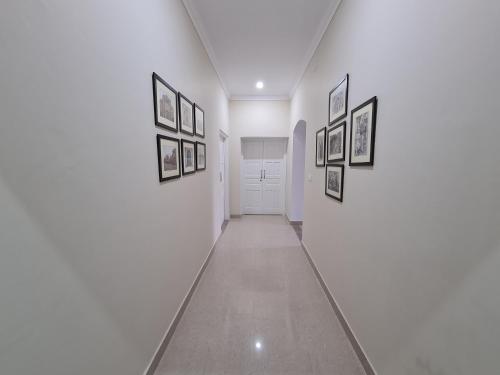 a hallway with pictures on the walls of a room at The Heritage Villa in Patiāla