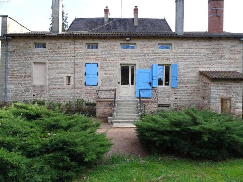 an old brick house with blue shutters on it at Gentilhommière de Collonges in Prissé