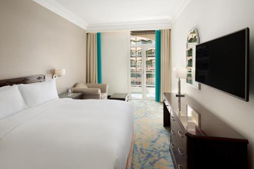 a hotel room with two beds and a television at Al Hamra Hotel Jeddah in Jeddah