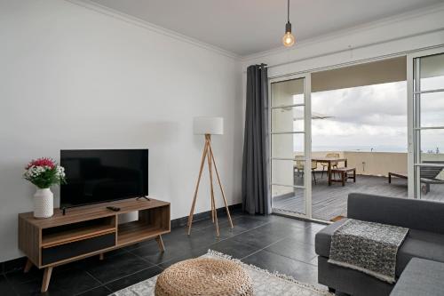 a living room with a tv and a couch at Casa Skyline by An Island Apart in Caniço
