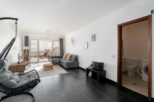 a living room with a couch and a chair at Casa Skyline by An Island Apart in Caniço