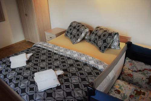 a bed with black and white sheets and pillows at Motel Roubenka in Týniště nad Orlicí