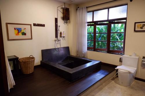 bagno con finestra e vasca nera. di Sunny V Hotel a Chiang Mai