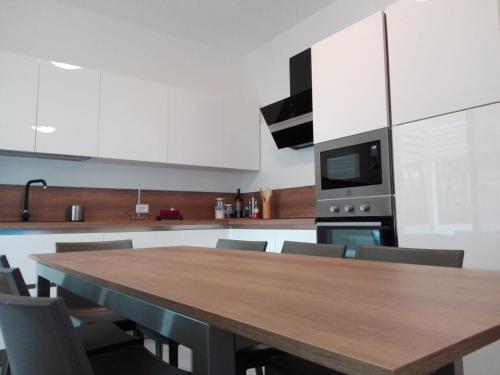 カオルレにあるVilla Serenaの木製のテーブルと椅子のある広いキッチン