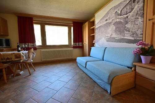 a living room with a blue couch and a table at Casa Caste in Bormio
