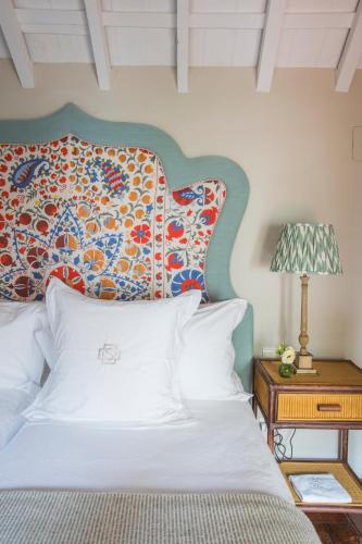 a bed with a colorful headboard and a table with a lamp at La Sacristía in Tarifa
