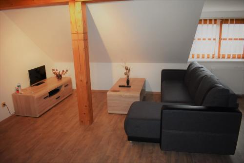 a living room with a couch and a tv at Motel Roubenka in Týniště nad Orlicí