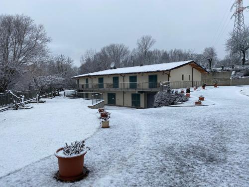 a house covered in snow with plants in the yard at B&B Oasi Vetoio in LʼAquila