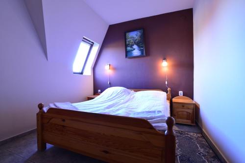 a small bedroom with a bed with white sheets at Thermal Panzió Sárvár in Sárvár