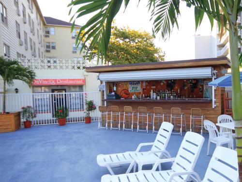 a patio with white chairs and a bar at Harrison Hall Hotel in Ocean City